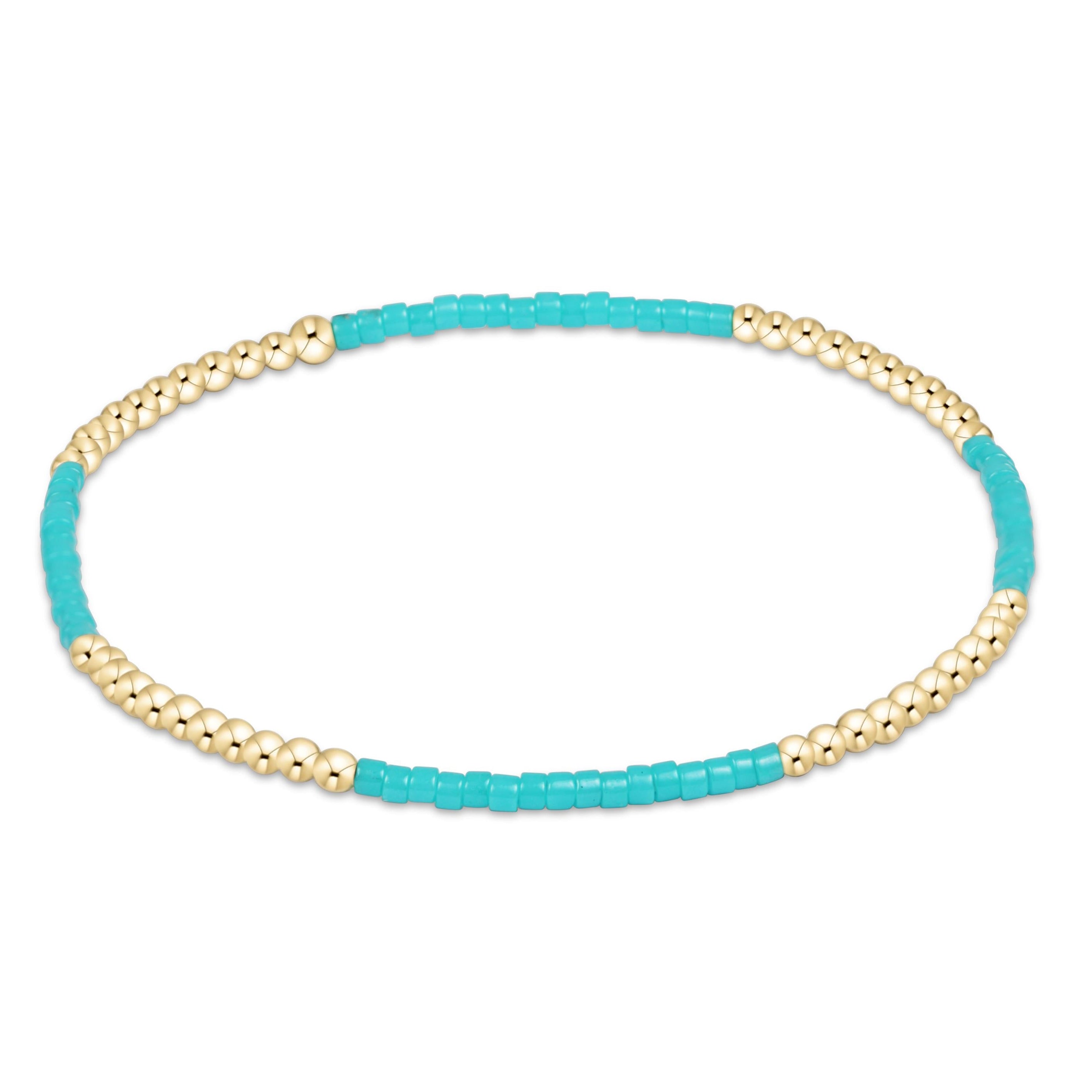 Turquoise and gold beaded bracelet on a white background