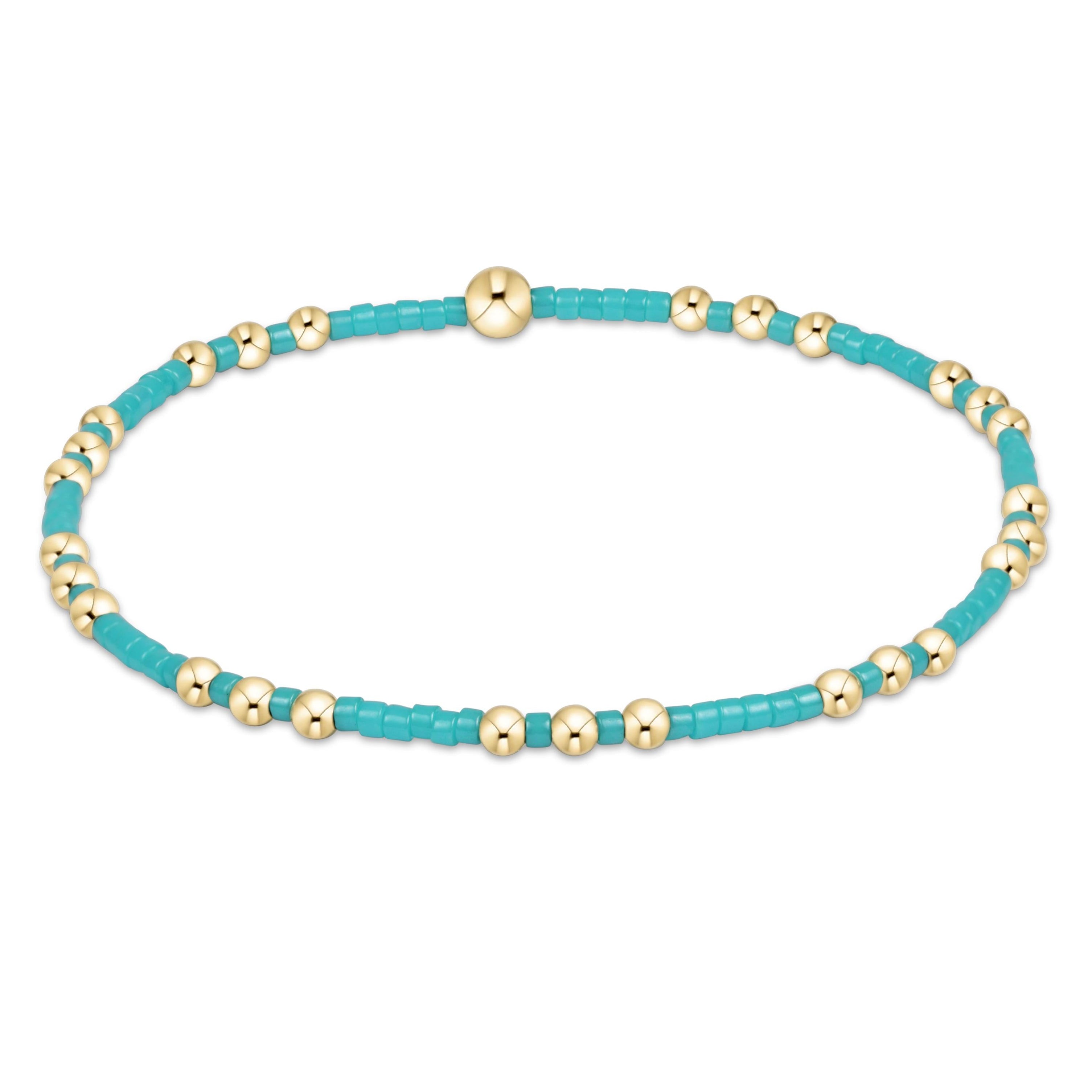 Turquoise and gold beaded bracelet on a white background