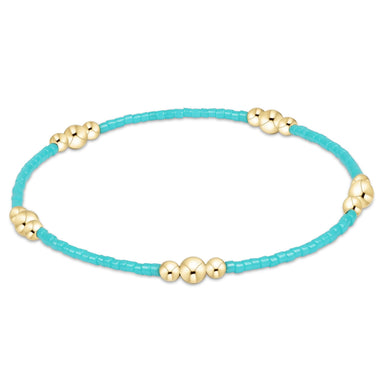 Turquoise bracelet with gold beads on a white background