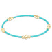 Turquoise bracelet with gold beads on a white background