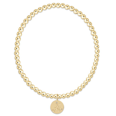 Gold beaded bracelet with a round tag on a white background