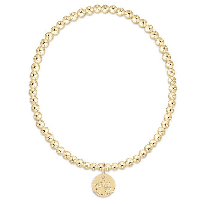Gold beaded bracelet with a round tag on a white background