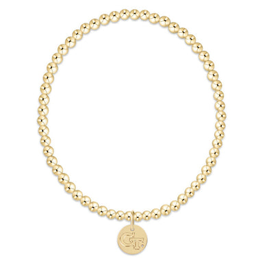 Gold beaded bracelet with a round tag on a white background