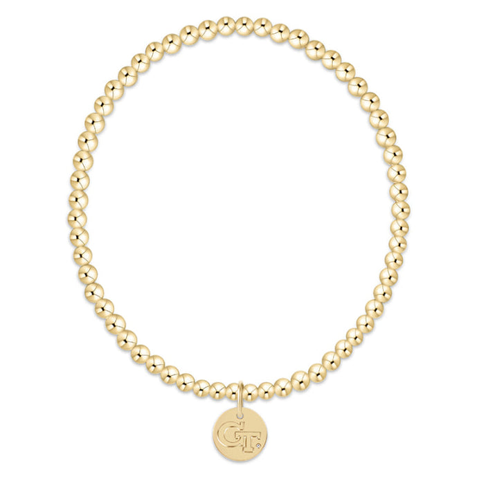 Gold beaded bracelet with a round tag on a white background