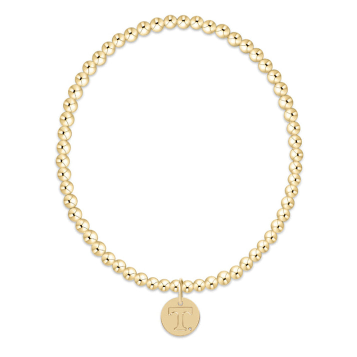 Gold beaded bracelet with a gold charm on a white background