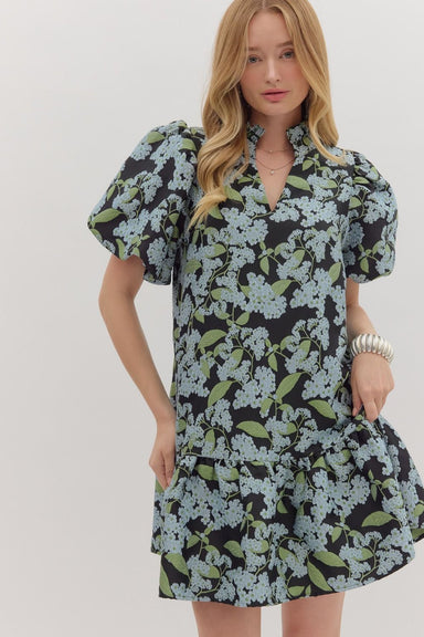 Woman wearing a floral dress with puff sleeves against a white background