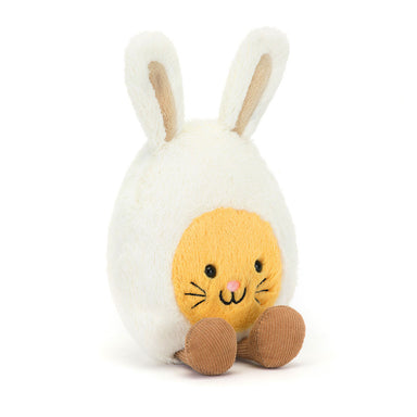White plush toy with a yellow face and brown feet on a white background