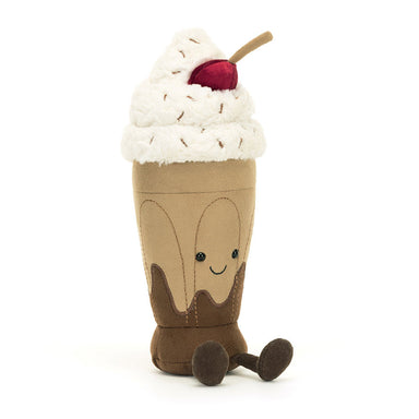 Plush toy resembling a chocolate milkshake with whipped cream and a cherry on top against a white background