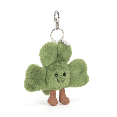 Plush keychain shaped like a green clover with a smiling face on a white background