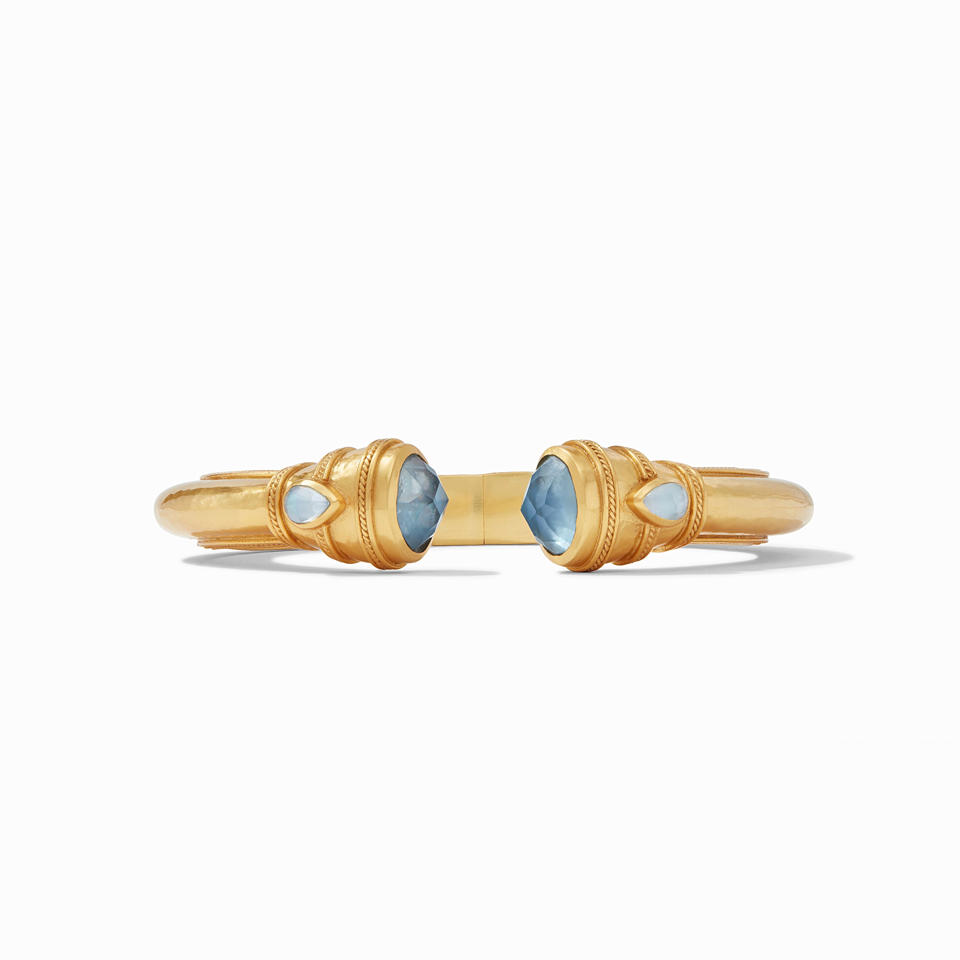 Gold bracelet with blue gemstones on a white background