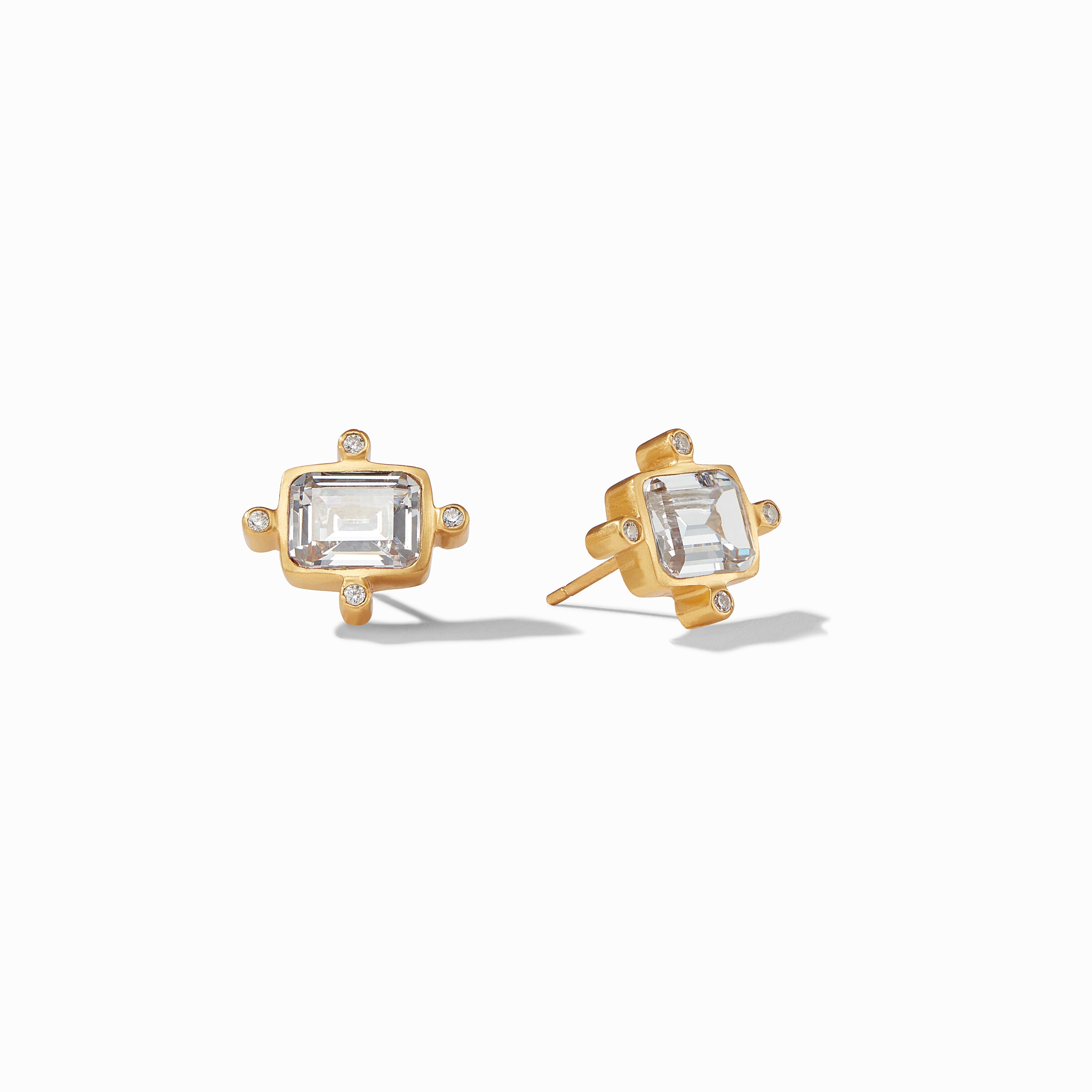 Gold earrings with clear gemstones on a white background