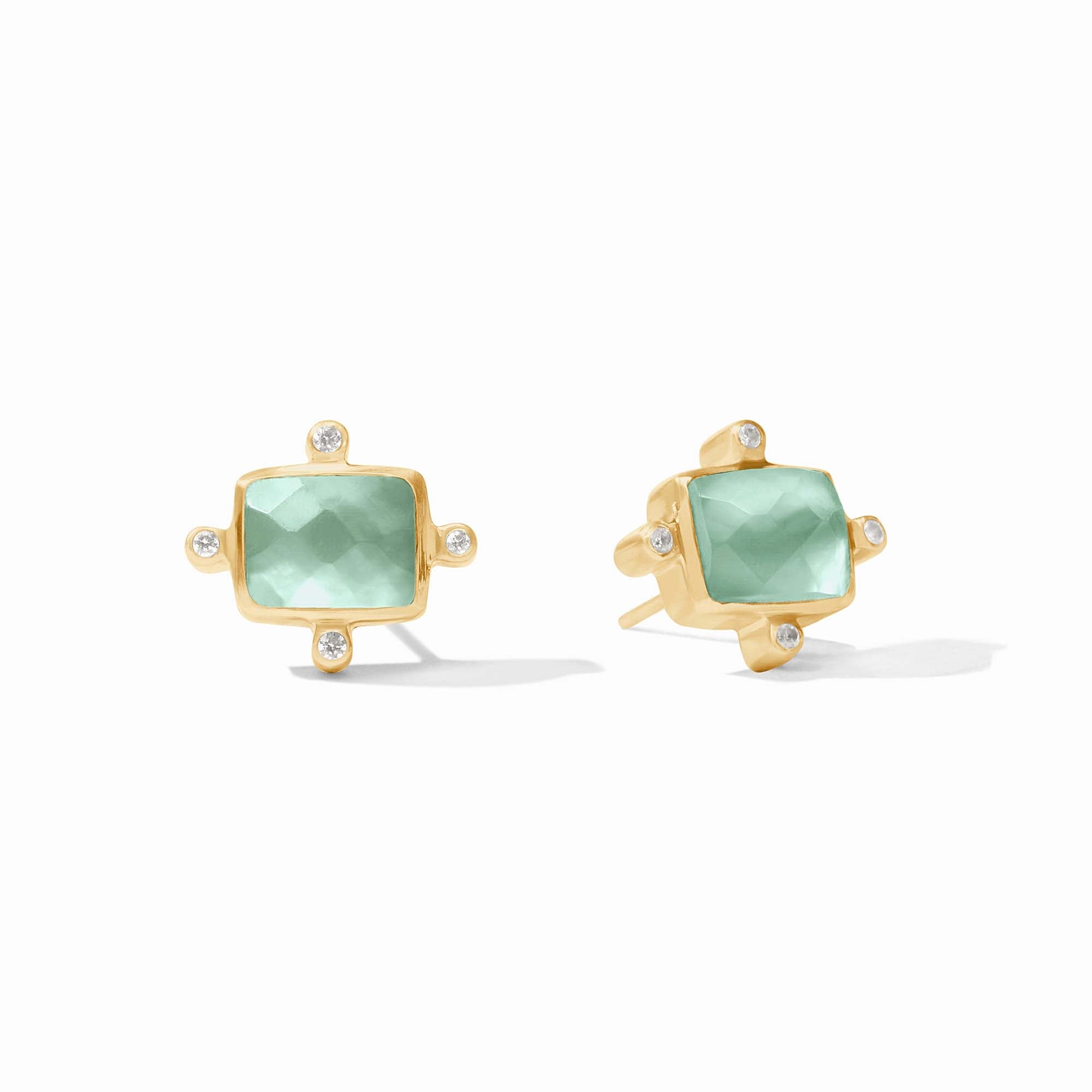 Gold earrings with green gemstones on a white background