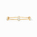 Gold bracelet with three white stones on a white background
