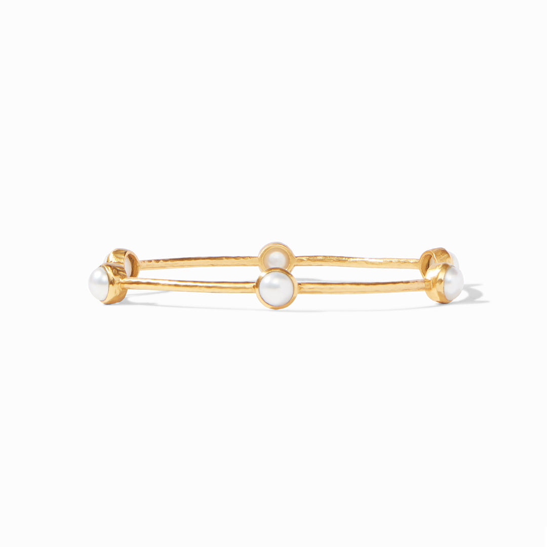 Gold bracelet with three pearl-like beads on a white background