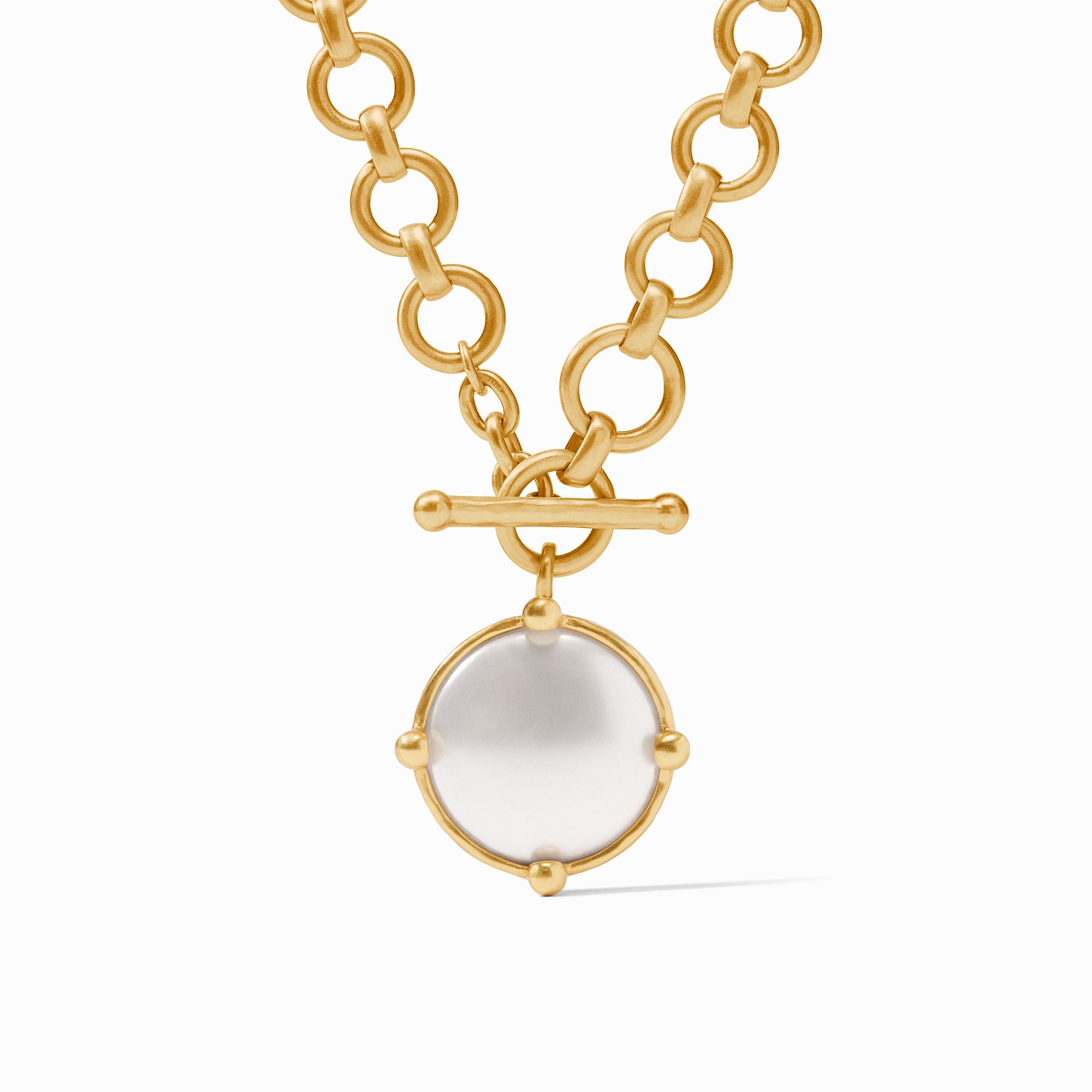 Gold necklace with a white pendant on a white background
