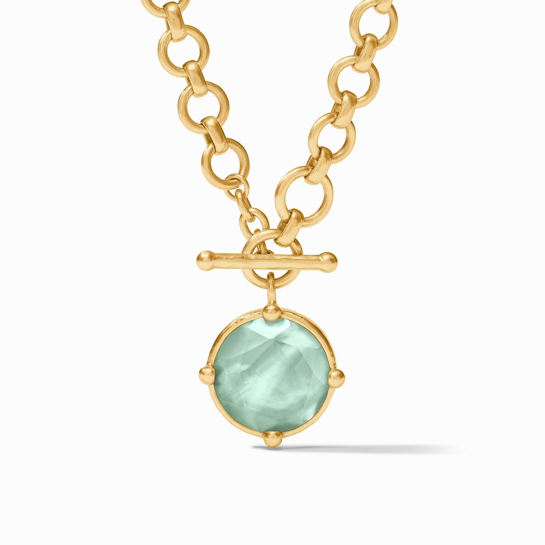 Gold necklace with a green pendant on a white background