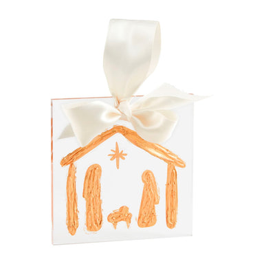 A gold acrylic nativity scene ornament with a white ribbon bow on top.