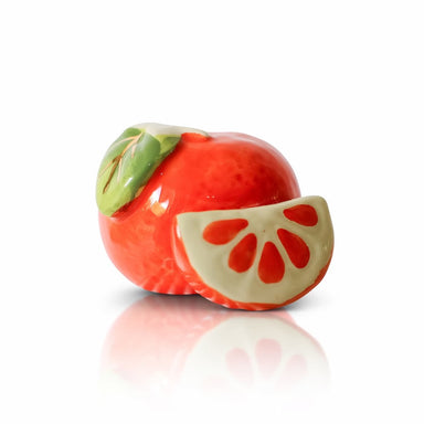 Decorative item resembling a sliced red fruit with green leaves on a white background