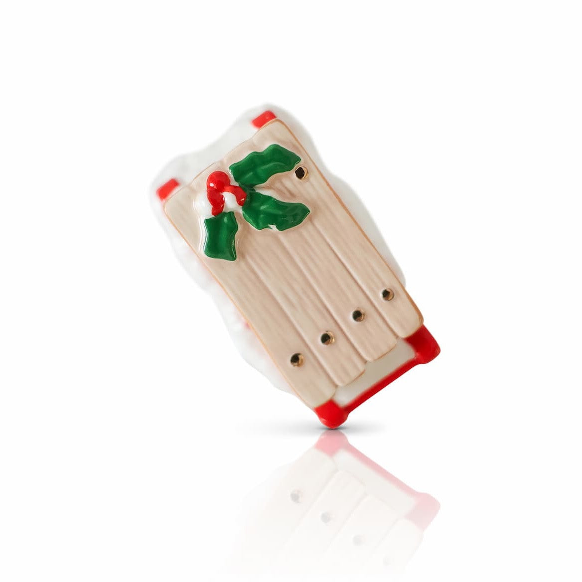 Wooden toy with red accents and holly decorations on a white background