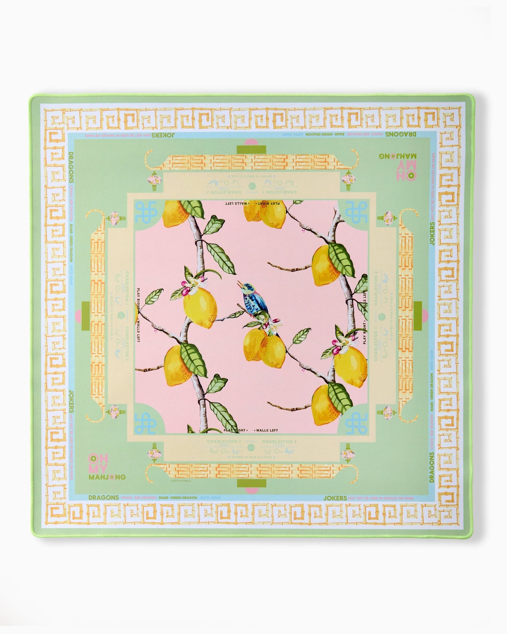 Decorative table mat with lemon design on a pink background, framed by decorative border.