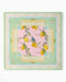 Decorative table mat with lemon design on a pink background, framed by decorative border.
