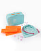 Teal box with orange straws and pink bags on a white background