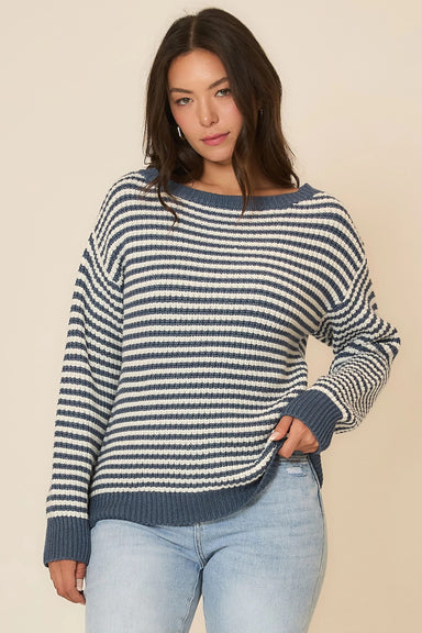 Woman wearing a blue and white striped sweater against a beige background
