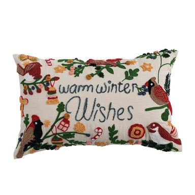 A rectangular lumbar pillow with a festive design including embroidered birds, flowers, and the text 'warm winter wishes'.