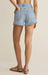 Light blue denim shorts worn by a person on a beige background