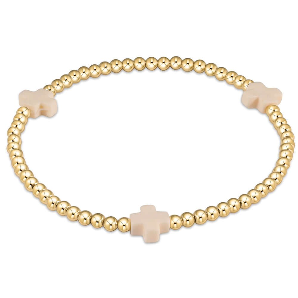 A gold-filled elastic bracelet with off-white beads and gold-filled bead caps.